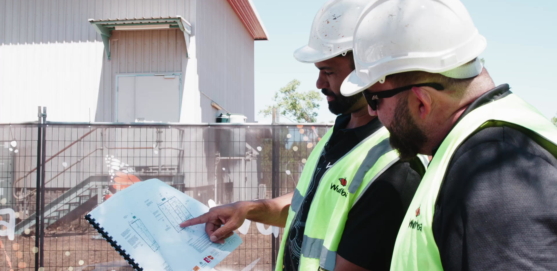 Two Wurrba team members in hi-vis reviewing site drawings
